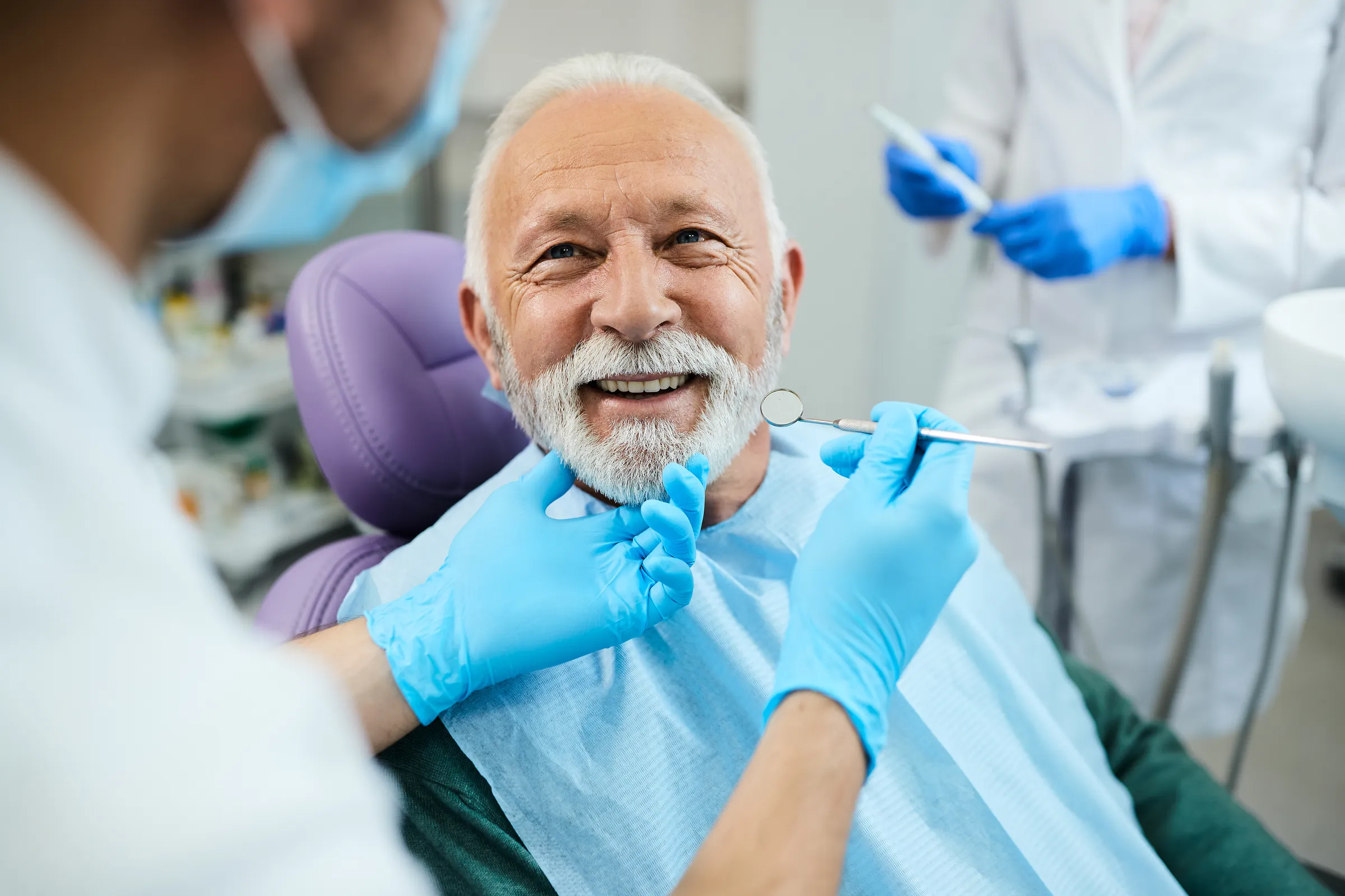 Smiling older man in a dental chair during treatment