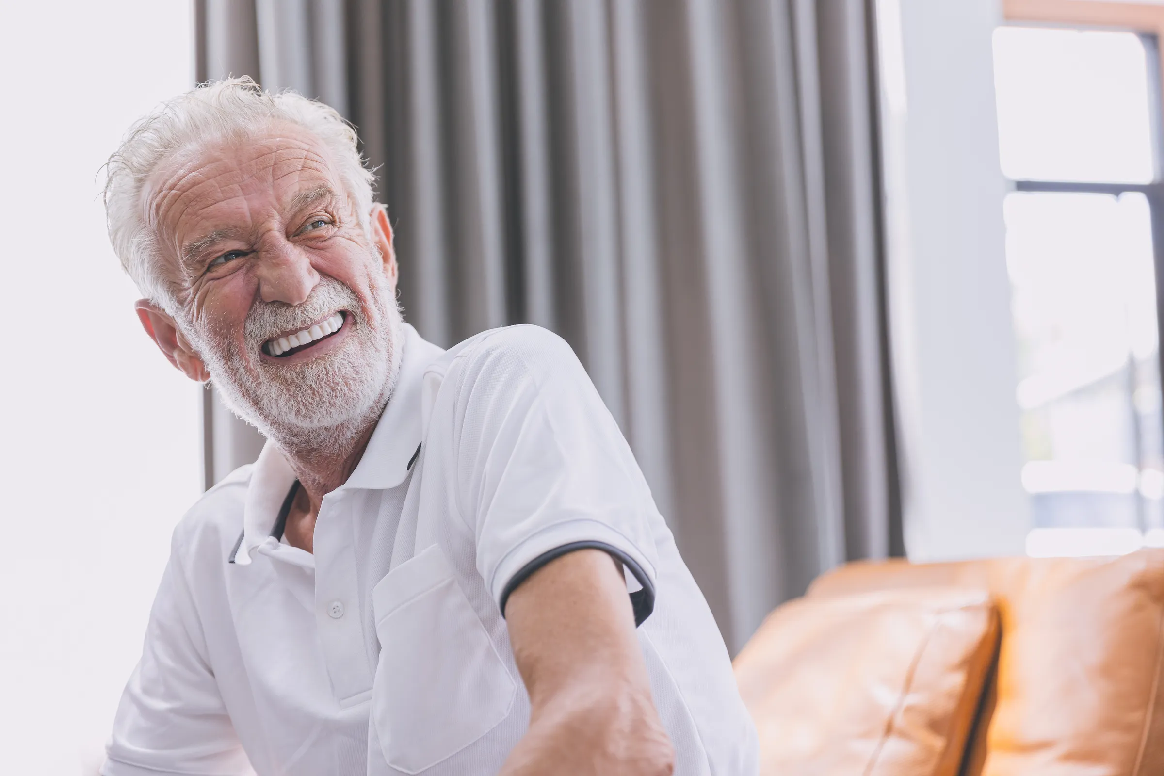 Smiling older man seated in a living room