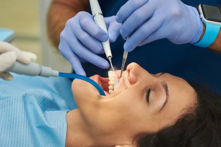 Dentist and assistant performing a deep cleaning on a patient