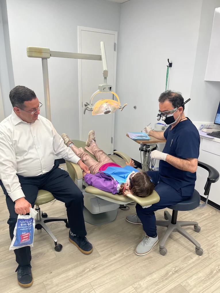 Dr. Karbasi treating a young patient with her parent