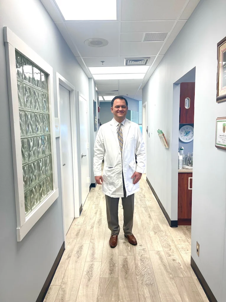 Dr. Karbasi in a white coat in the office hallway